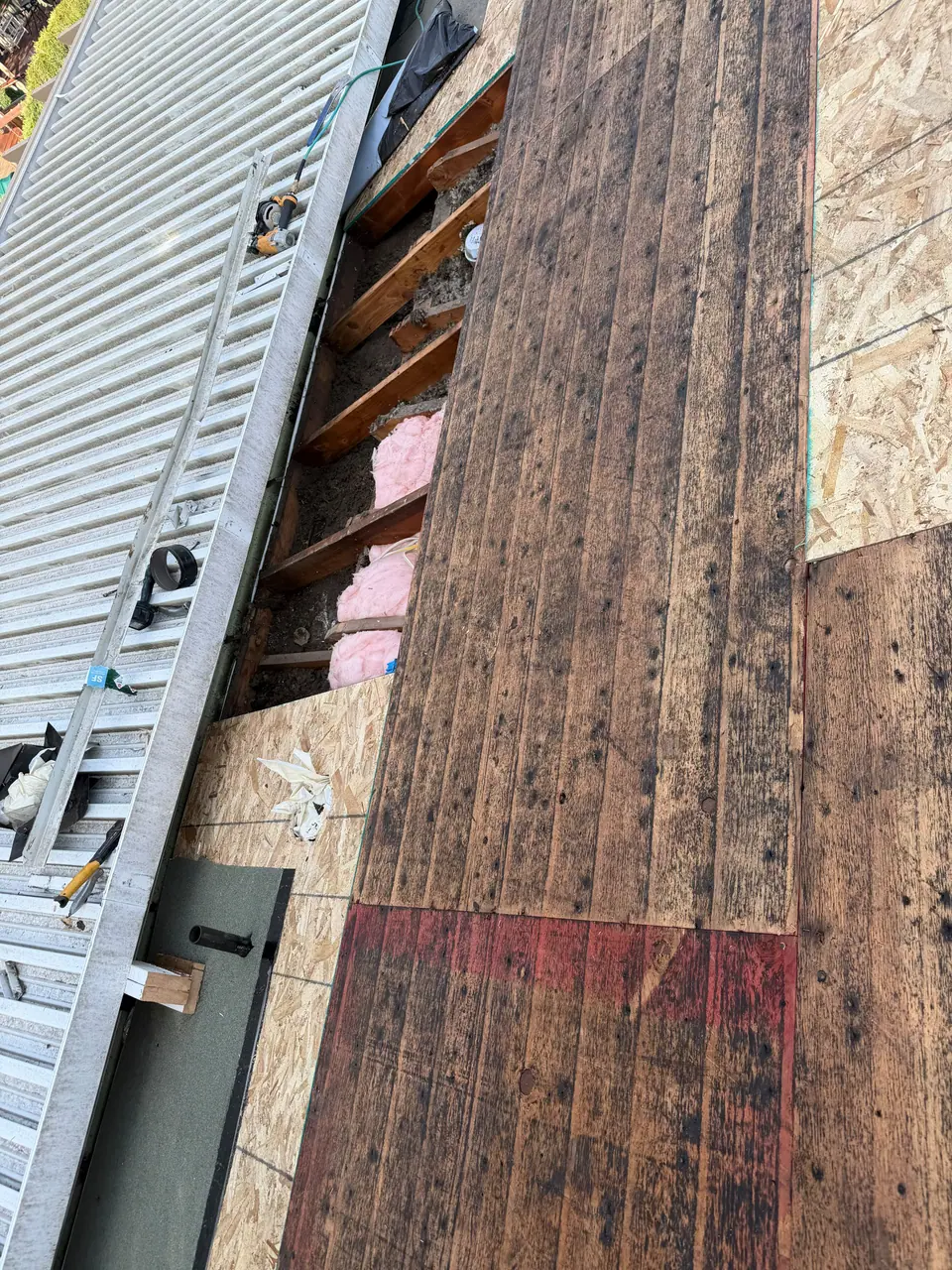 Old boards exposed next to new plywood