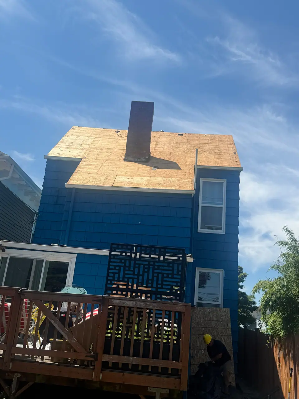 New plywood deck and chimney on a blue house