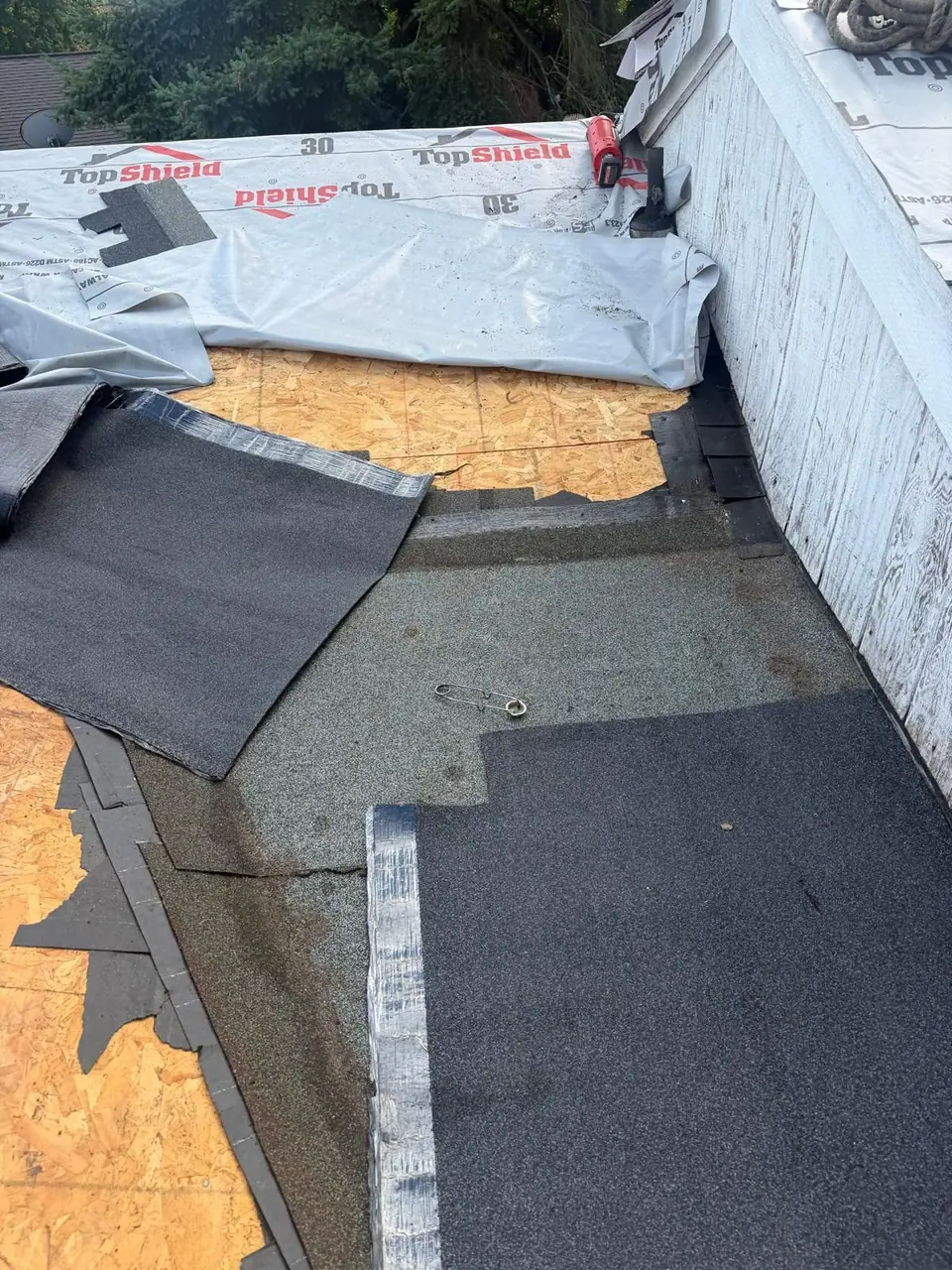 Old roofing coming off a low-slope section